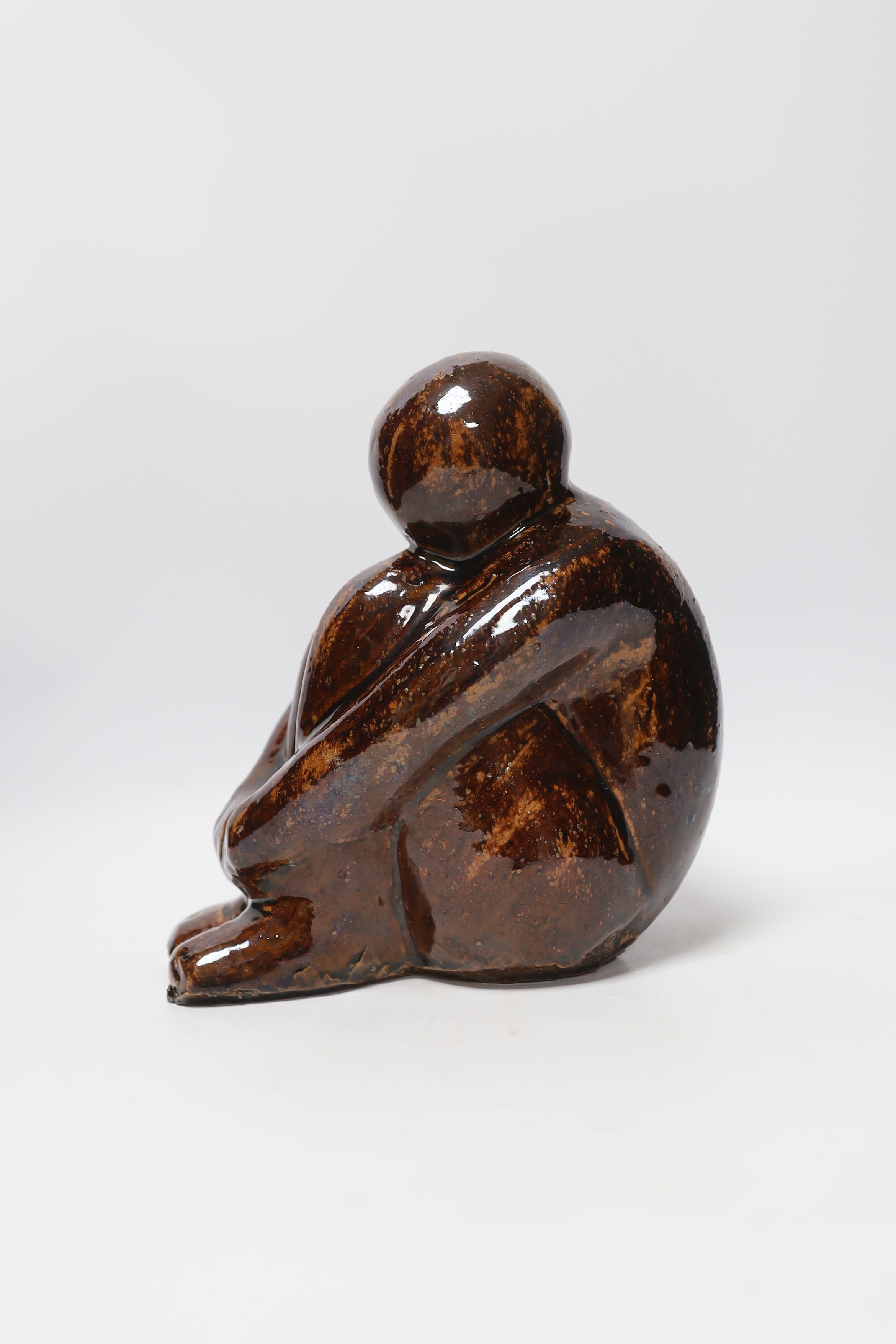 A 20th century tenmoko glazed pottery figure of a seated figure, 22cm